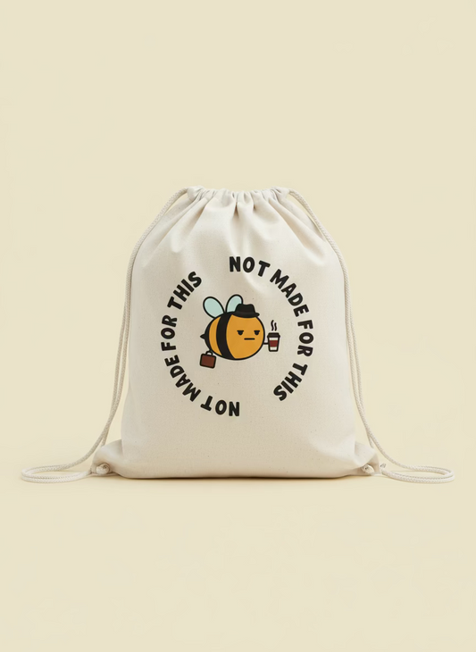 Drawstring bag with a bee graphic and text 'Not Made for This' on a gravel surface.