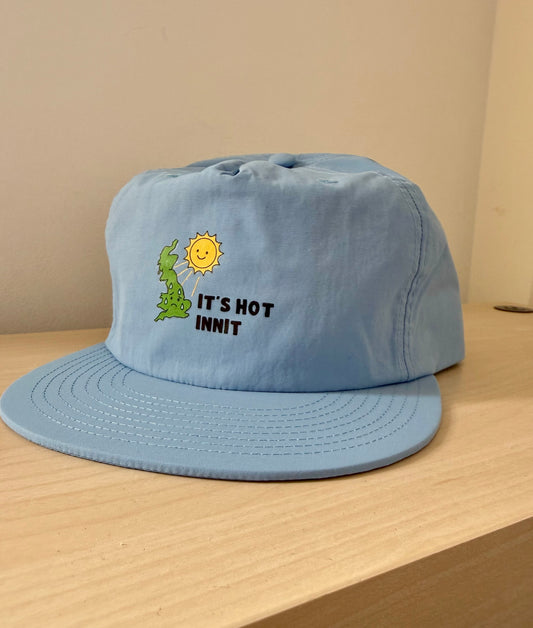 Not Made For This Light blue cap with sun and text design on a wooden surface