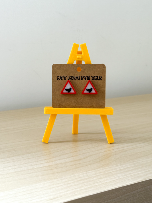 Not Made For This Earring card with warning triangle design on a small yellow easel against a white background